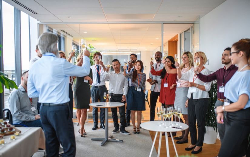 Team celebrating a product launch with a toast in a modern office, highlighting success in building a digital brand.